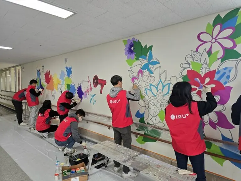 수원 아름학교에서 LGU+임직원들이 벽화그리기 봉사활동을 진행하고 있는 모습. (제공 LGU+)