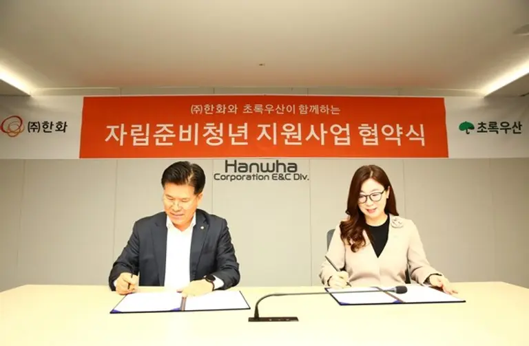 전창수 한화 인사지원실장과 신정원 초록우산 사회공헌협력본부장이 협약서에 사인을 하고 있다. (사진제공=한화)