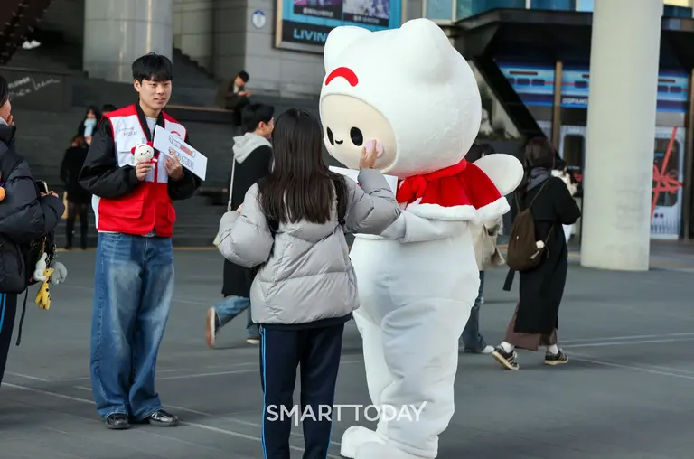 희망브리지 공식 캐릭터 ‘희망프렌즈’가 서울 용산역 광장에서 진행한 시민 참여 홍보 캠페인 현장에서 시민과 인사를 나누고 있다. (사진제공=희망브리지)