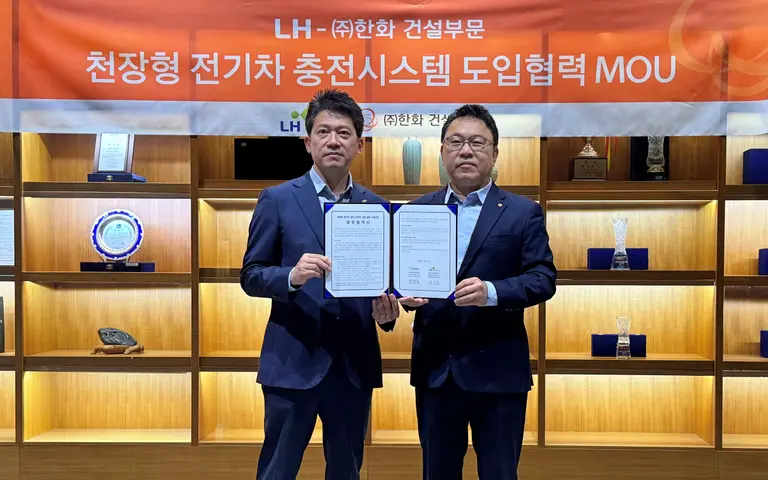 (오른쪽부터) 박광호 한화 건설부문 건축지원실장과 최한봉 LH 공공주택전기처장이 차세대 천장형 전기차 충전시스템 ‘EV에어스테이션’의 시범도입을 위한 협약을 체결하고 기념촬영을 하고 있다. 출처=한화 건설부문