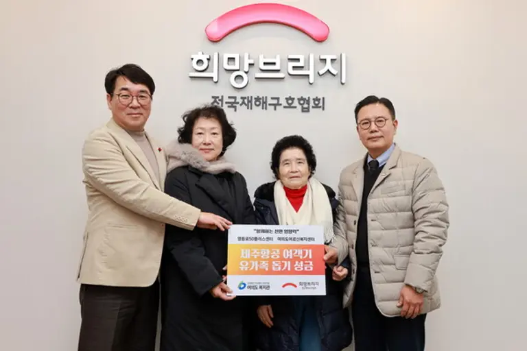 신훈 희망브리지 사무총장(오른쪽)이 박철상 여의도복지관장(왼쪽)과 어르신 대표 최경자·설진남 씨로부터 제주항공 여객기 사고 유가족 돕기 성금을 전달받고 있다(사진제공=희망브리지)