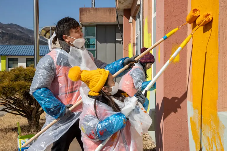호반그룹 임직원 봉사단 호반사랑나눔이가 충북 제천 화당초등학교 외벽 도색작업을 하고 있다. (사진=호반그룹)
