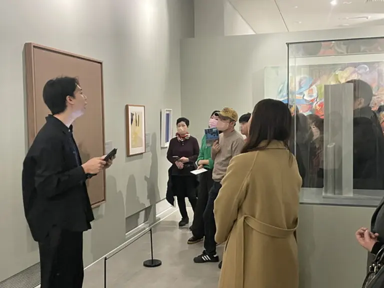  * 관람객들이 도슨트에게서 작품 설명을 듣고 있다> /제공: 이엔에이파트너스