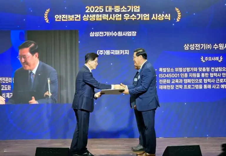 삼성전기 글로벌안전센터장 임승용 부사장이 고용노동부 김문수 장관으로부터 선정서를 받고 있다. 