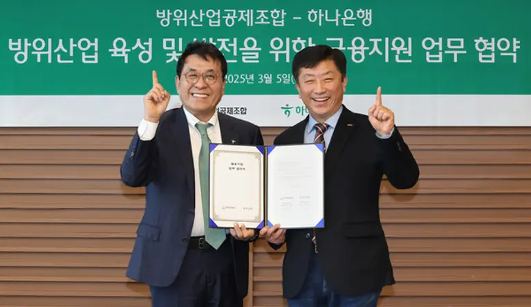 하나은행은 5일 방위산업공제조합과 K-방위산업의 육성 및 금융 지원을 위한 업무협약을 체결했다. 이날 협약식에 참석한 김진우 하나은행 중앙영업그룹 부행장(왼쪽)과 김희철 방위산업공제조합 상근부이사장이 기념촬영을 하고 있다. [출처: 하나은행]