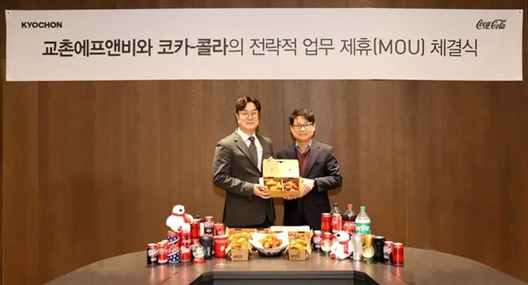 지난 6일 MOU 체결식에 참석한 교촌에프앤비 이상로 국내사업부문장(부사장)(왼쪽)과 코카콜라음료 신기섭 디지털영업부문장(오른쪽)이 MOU를 체결한 후 기념 사진을 찍고 있다.