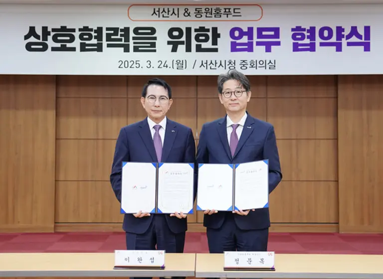 24일 서산시청에서 정문목 동원홈푸드 대표(오른쪽)와 이완섭 서산시장(왼쪽)이 업무 협약을 맺고 기념 촬영을 하고 있다. 