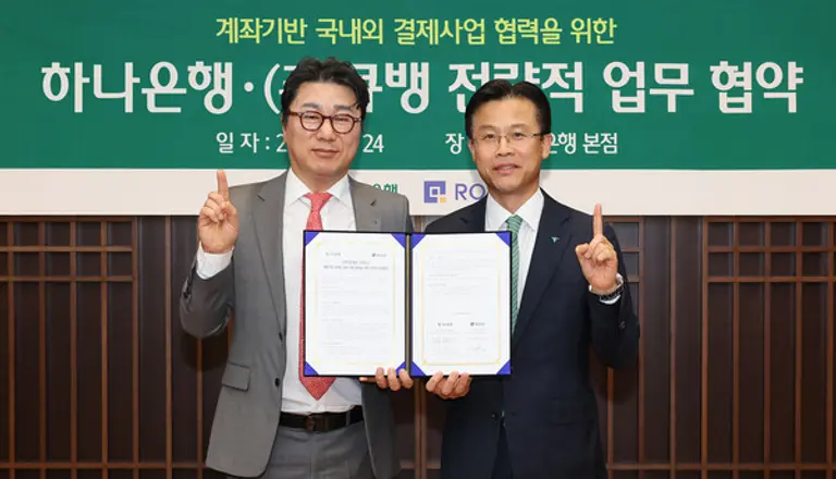 하나은행은 지난 24일 큐뱅과 국내외 결제사업 협력을 위한 업무협약을 체결했다. 이날 협약식에 참석한 서유석 하나은행 기업그룹 부행장(오른쪽)이 강신혁 큐뱅 대표와 협약서를 들고 기념촬영을 하고 있다. [출처: 하나은행]