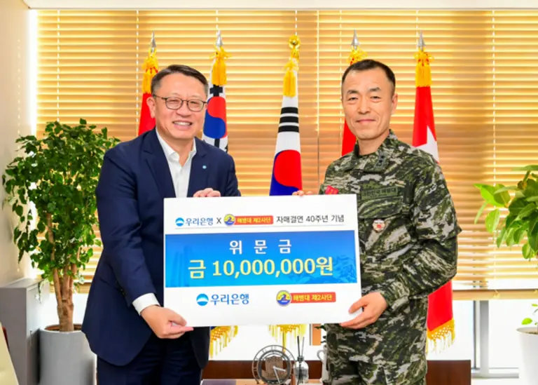 지난 8일 해병대 2사단에서 열린 위문금 전달식에서 정진완 우리은행장(왼쪽)과 최영길 해병대 2사단장이 자매결연 40주년을 맞아 기념촬영을 하고 있다. [출처: 우리은행]