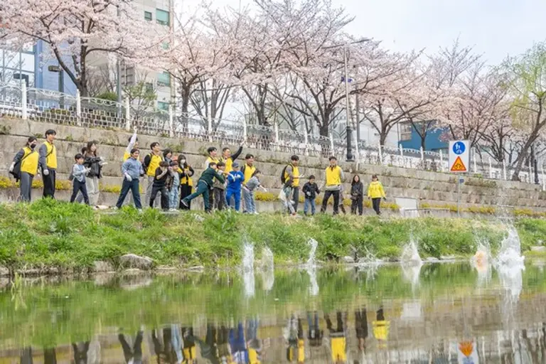 자원봉사자들이 성북천 환경 정화를 위해 사용될 EM흙공 던지고 있다. (사진제공=HDC현대산업개발)