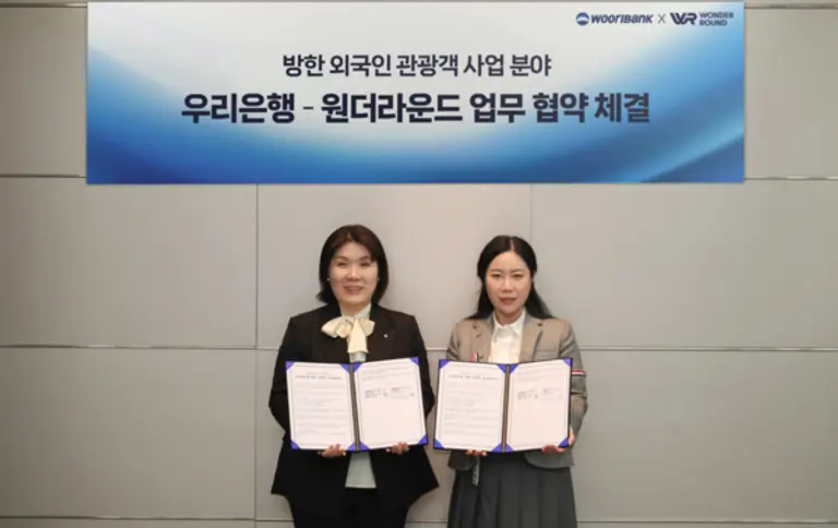 우리은행 방윤선 외환사업부장(왼쪽)과 원더라운드 묘칭(MIAO QING) 대표이사가 방한 외국인 관광객 사업 분야 협약 체결했다. [출처: 우리은행]