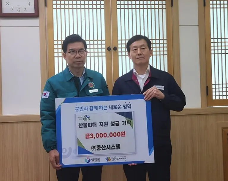 중산시스템 이관석 전무(오른쪽)가 김광열 영덕군수를 만나 성금을 전달하고 있다. (중산시스템 제공)