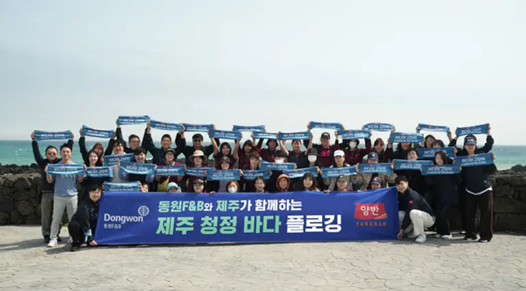 18일 서귀포시 표선면에서 진행된 ‘제주 청정 바다 플로깅’ 행사에서 동원F&B 직원들이 기념 사진 촬영을 하고 있다.