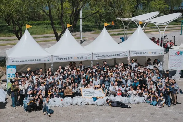 KB국민은행 임직원과 가족이 지난 26일 서울 반포한강공원에서 플로깅 행사 후 수거한 쓰레기봉투들과 함께 기념사진을 촬영했다. [출처: KB국민은행]