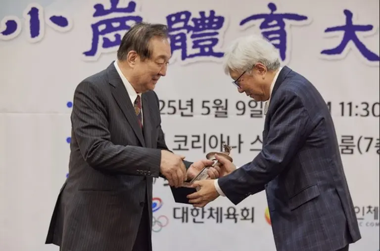 이인정 회장(오른쪽)이 정대철 소강민관식육영재단 이사장으로부터 대상 트로피를 받고 있다. (사진=대한산악연맹)