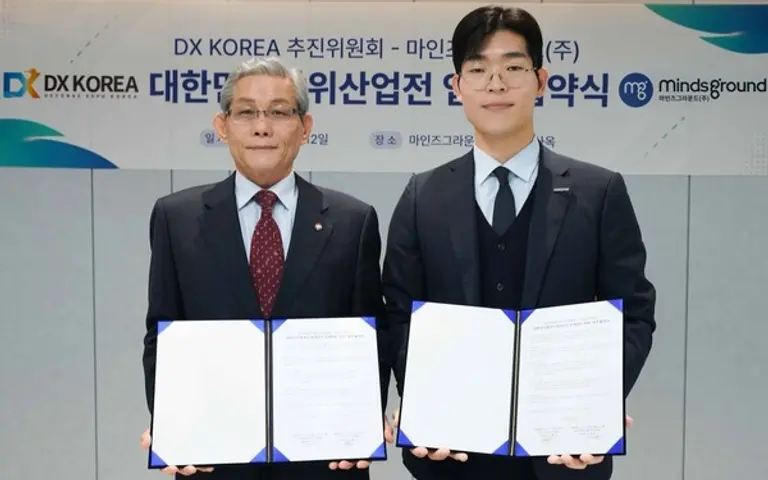  * 마인즈그라운드(주) 민환기 대표(사진 오른쪽)와 DX KOREA 2026 김영후 추진위원장이 대한민국 방위산업전(DX KOREA) 2026 업무협약서를 12일 체결했다.