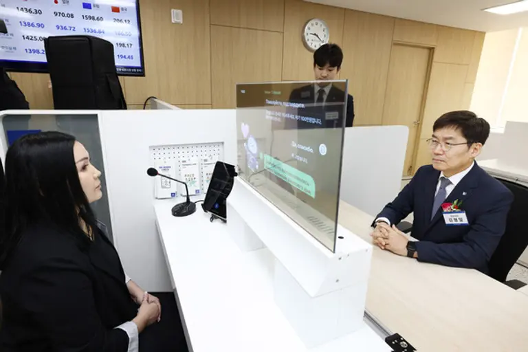 사진은 13일 경기도 안산시에 위치한 기업은행 안산외국인금융센터에서 김형일 IBK기업은행 전무이사(오른쪽)가 실시간 통번역서비스 시스템을 시연하고 있는 모습