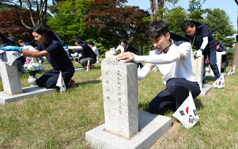 HS효성 임직원들이 국립서울현충원에서 묘비를 닦고 묘역 정화 활동을 하고 있다. (사진제공=HS효성)