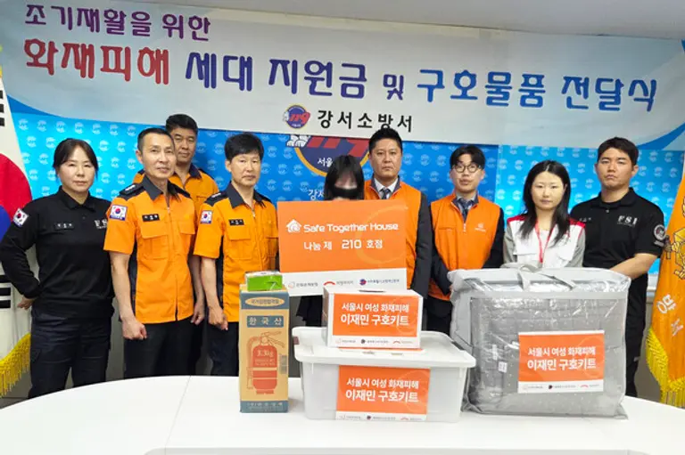 희망브리지와 한화손해보험 관계자가 서울 강서소방서에서 화재 피해를 입은 여성 가정에 위로금과 구호키트를 전달하고 기념촬영을 하고 있다(사진제공=희망브리지)