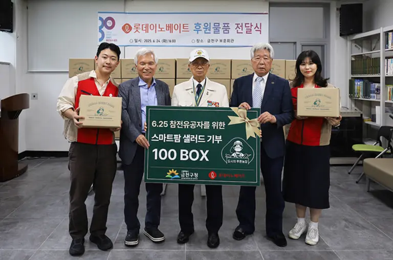 롯데이노베이트 봉사자들이 6∙25 참전유공자들과 기념사진을 찍고 있다.