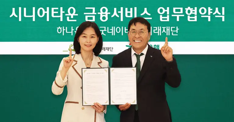 이날 협약식에 참석한 김진우 하나은행 중앙영업그룹 부행장(사진 오른쪽)이 양진옥 굿네이버스 미래재단 대표(사진 왼쪽)와 함께 업무협약서를 들고 기념 촬영을 하고 있다.