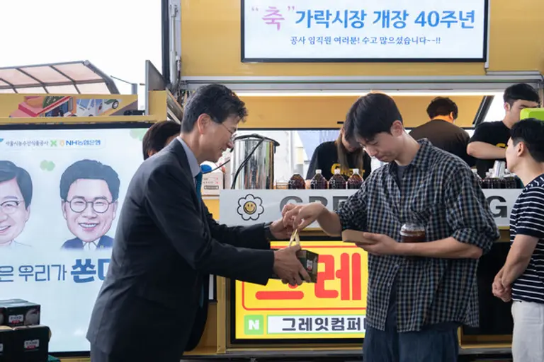 NH농협은행 강태영 은행장이 간식행사에서 쌀 소비 촉진 홍보활동의 일환으로 농협 즉석밥을 나누어 주고 있다.