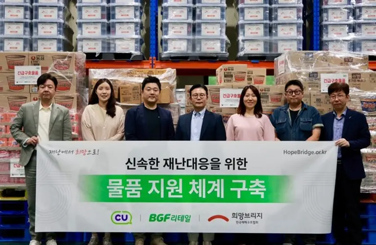 희망브리지와 BGF리테일 관계자들이 재난 발생 시 신속한 이재민 지원을 위한 구호물품 비축 체계 구축을 기념하며 파주 재해구호물류센터에서 기념촬영을 하고 있다(사진제공=희망브리지)