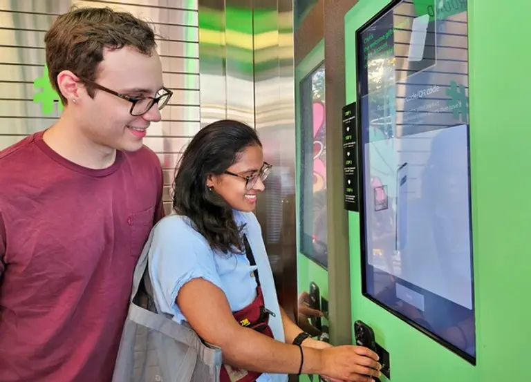 미국인 탄비(Tanvi, 오른쪽)씨와 러셀(Russell, 왼쪽)씨가 올리브영 명동 타운에 마련된 벤딩머신으로 글로벌몰에 가입하는 모습. 