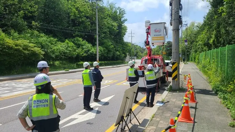 한전주 위의 발판에 올라 작업하는 모습을 지켜보고 있는 박상형 한전KDN 사장(오른쪽 두번째)