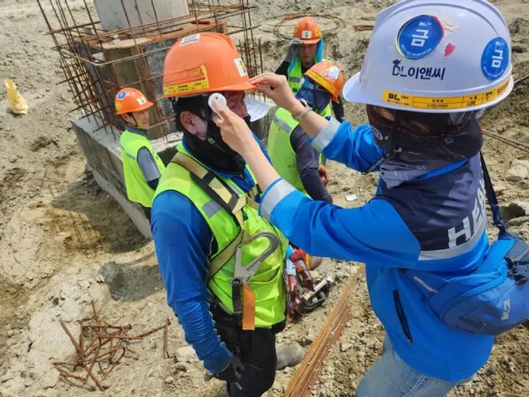 DL이앤씨 현장 안전보건관리자가 근로자의 체온을 측정하고 건강상태를 확인하고 있다. (사진제공=DL이앤씨)