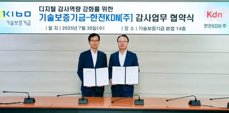 업무협약서에 서명을 진행하고 있는 김문호 한전KDN 상임감사와 임명배 기술보증기금 상임감사(오른쪽 부터)