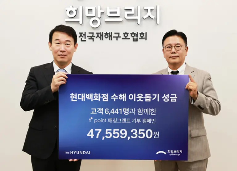 현대백화점 양명성 영업전략담당 상무(왼쪽)와 희망브리지 신훈 사무총장(오른쪽)이 18일 서울 희망브리지 전국재해구호협회에서 ‘H.Point 매칭그랜트 기부 캠페인’을 통해 마련된 성금 4700여만원을 전달한 뒤 기념촬영을 하고 있다(사진제공=희망브리지)