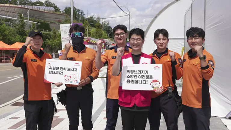 전국재해구호협회 직원이 긴급구호종합훈련에 참여한 소방대원들에게 간식을 지원한 뒤 기념촬영을 하고 있다.(사진=전국재해구호협회)