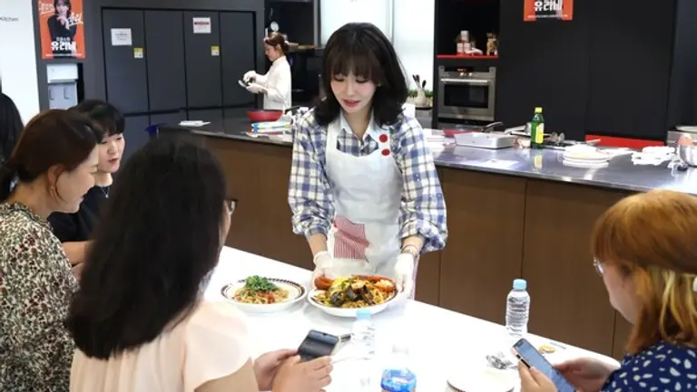 배우 이유리가 조리한 음식을 고객들에게 직접 전달하고 있다.
