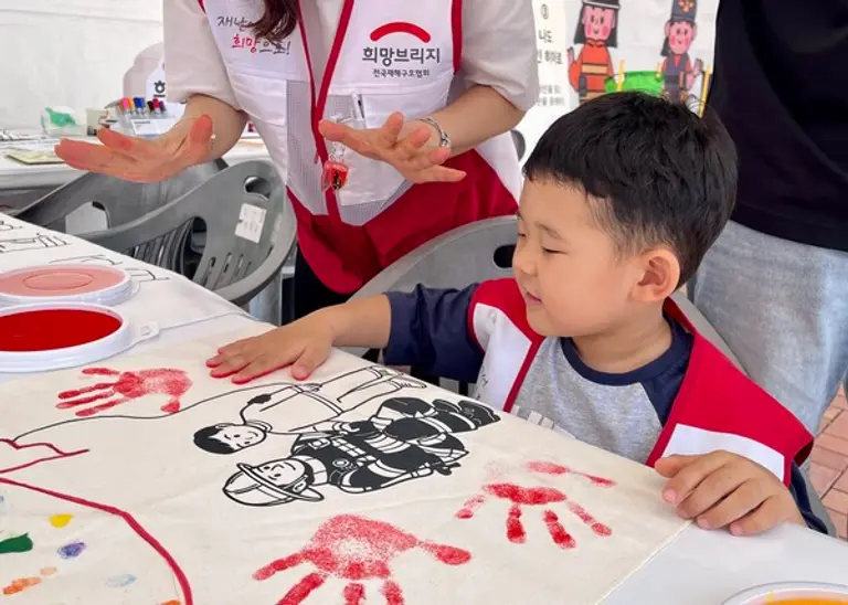 희망브리지 ‘특명! 소방관을 응원하라’ 부스에 참가한 어린이가 손도장을 찍으며 소방관 응원에 동참하고 있다. (사진제공=희망브리지)