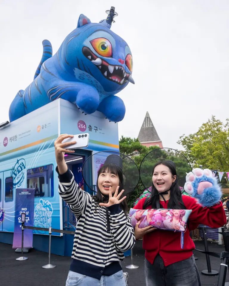 에버랜드의 케이팝 데몬 헌터스 테마존에서 모델들이 인기 굿즈를 들고 사진을 찍고 있다. (제공 에버랜드)