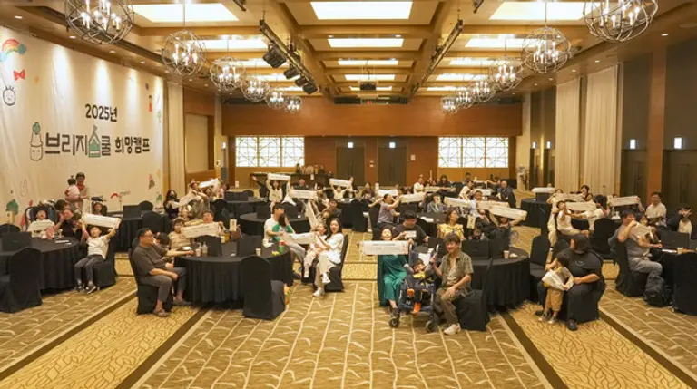 ‘2025 브리지스쿨 희망캠프’에 참여한 중증질환 아동과 가족들이 단체사진을 촬영하고 있다.(사진=희망브리지)