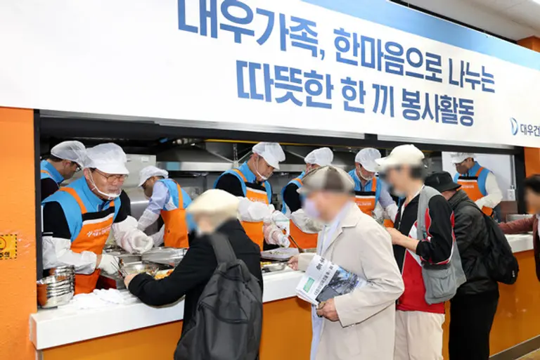 대우건설 김보현 대표이사(왼쪽)와 심상철 노동조합 위원장(오른쪽)이 무료 급식 봉사활동에 참여하고 있다.(사진제공=대우건설)