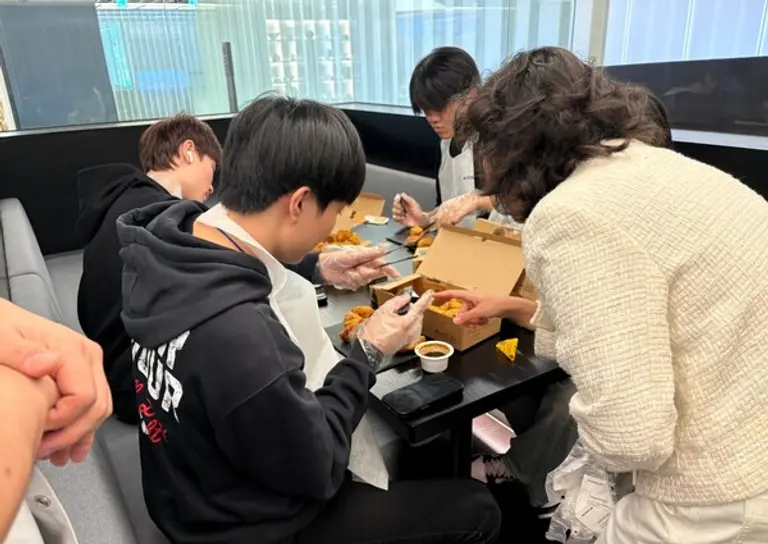 지난 23일 교촌에프앤비 판교 본사에서 진행된 ‘기업탐방’ 프로그램에 참여한 이주배경 청소년들이 교촌치킨을 조리하고 있는 모습