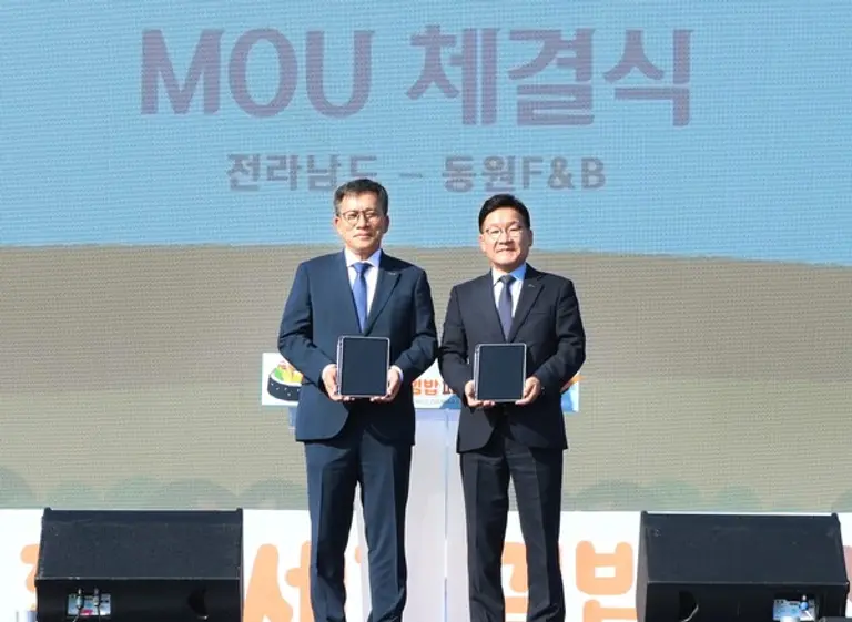 24일 목포문화예술회관에서 문상철 동원F&B 영업본부장(왼쪽)과 강위원 전라남도 경제부지사가 업무 협약을 체결하고 기념 촬영을 하고 있다. (사진제공=동원F&B)