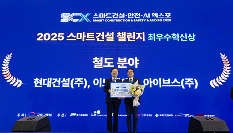 5일 킨텍스에서 열린 스마트건설·안전·AI 엑스포에서 진행된 ‘2025 스마트건설 챌린지’ 시상식에서 현대건설 토목설계실 이정한 상무(오른쪽)가 김윤덕 국토교통부장관으로부터 철도 분야 최우수 혁신상을 수여받은 후 기념사진을 촬영하고 있다. (사진=현대건설)