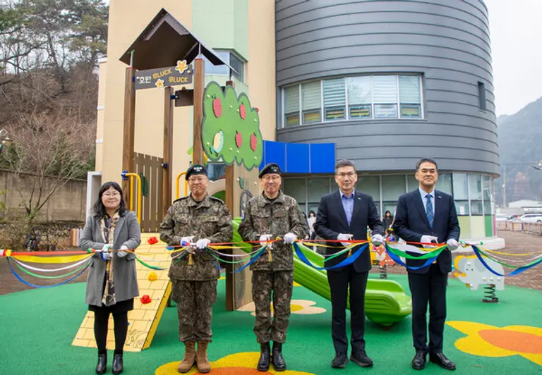 호반그룹이 강원도 인제군에 위치한 육군 3군단 어린이집에 ‘호반 무럭무럭 놀이터’를 전달했다. 문갑 호반건설 경영부문대표(오른쪽 두번째)와 육군 3군단장 등 관계자들이 전달식에서 기념 촬영을 하고 있다. (사진제공=호반그룹)