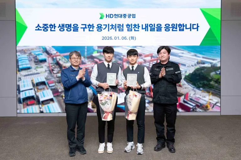 금석호 HD현대중공업 사장(왼쪽)이 6일 시민의 생명을 구한 윤형민 기사(오른쪽)의 아들 윤재준군(오른쪽 두번째)과 그의 친구 문현서군을 회사로 초청해 격려하고 있다. HD현대중공업 제공