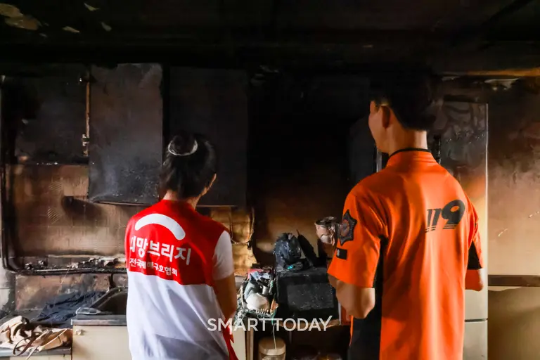 희망브리지 직원이 지난해 서울 광진구에서 발생한 화재 피해 세대를 방문해 광진소방서 화재조사관으로부터 화재 피해 상황에 대한 설명을 듣고 있다. (사진제공=희망브리지)