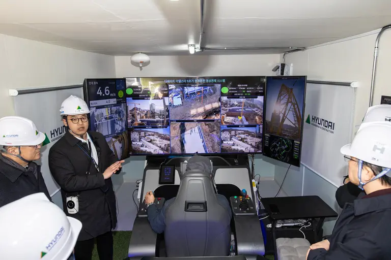 현대건설의 ‘원격제어 타워크레인’ 기술 시연회에 참관한 국토교통부, 동반성장위원회, 경기도청 등 유관 공공기관 및 스마트건설 관계자들이 설명을 듣고 있다. (사진제공=현대건설)