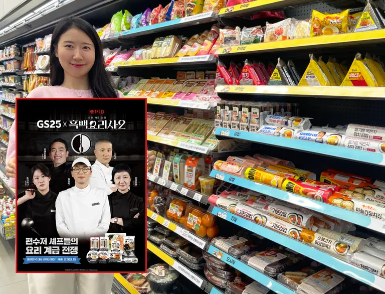 GS25에서 모델이 간편식품 진열대 앞에서 흑백요리사2 컬배버 상품 출시 안내 홍보물을 들고 있다. (사진=GS리테일)
