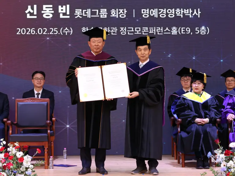 25일 대전 카이스트(KAIST) 본원에서 열린 2026년도 명예박사 학위수여식에서 신동빈 롯데 회장(왼쪽)이 이광형 총장으로부터 명예경영학 박사 학위를 받고 있다. 롯데 제공