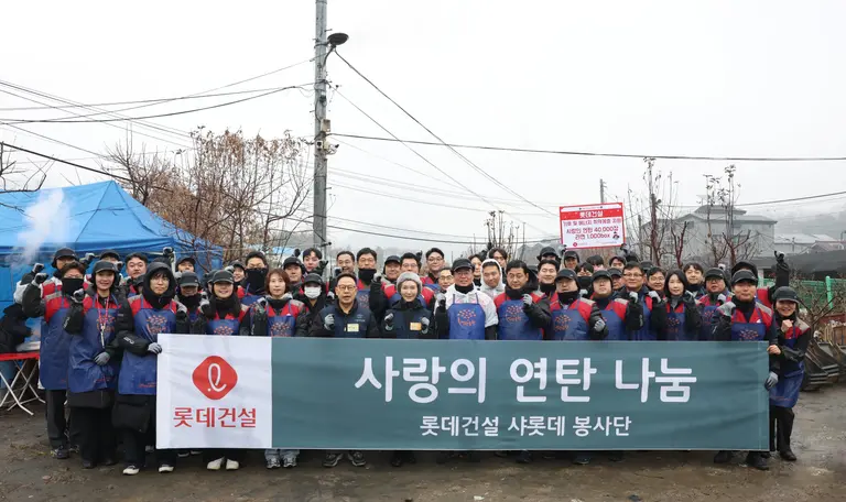 롯데건설 오일근 대표와 임직원들이 ‘사랑의 연탄 나눔’ 봉사활동에 참여해 기념촬영을 하고 있다.(사진=롯데건설)