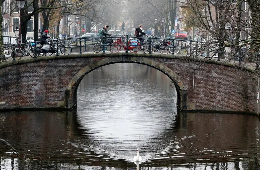 Cyclist ride on a bridge in central Amsterdam, Netherlands, December 1, 2017. REUTERS/Yves Herman - RC184E3A4050