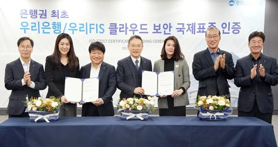  * 우리은행(은행장 이원덕)과 우리에프아이에스(대표 고정현)가 6일 마포구 소재 우리에프아이에스 본점에서 ISO 27017 국제 표준 클라우드 보안인증 수여식을 진행했다. 고정현 우리은행 IT그룹 부행장 겸 우리에프아이에스 대표(가운데), 김백수 우리은행 정보보호그룹 부행장(왼쪽 세번째), 이소영 DNV BA 코리아 대표(왼쪽 두번째)가 관계자들과 기념촬영을 하고 있다